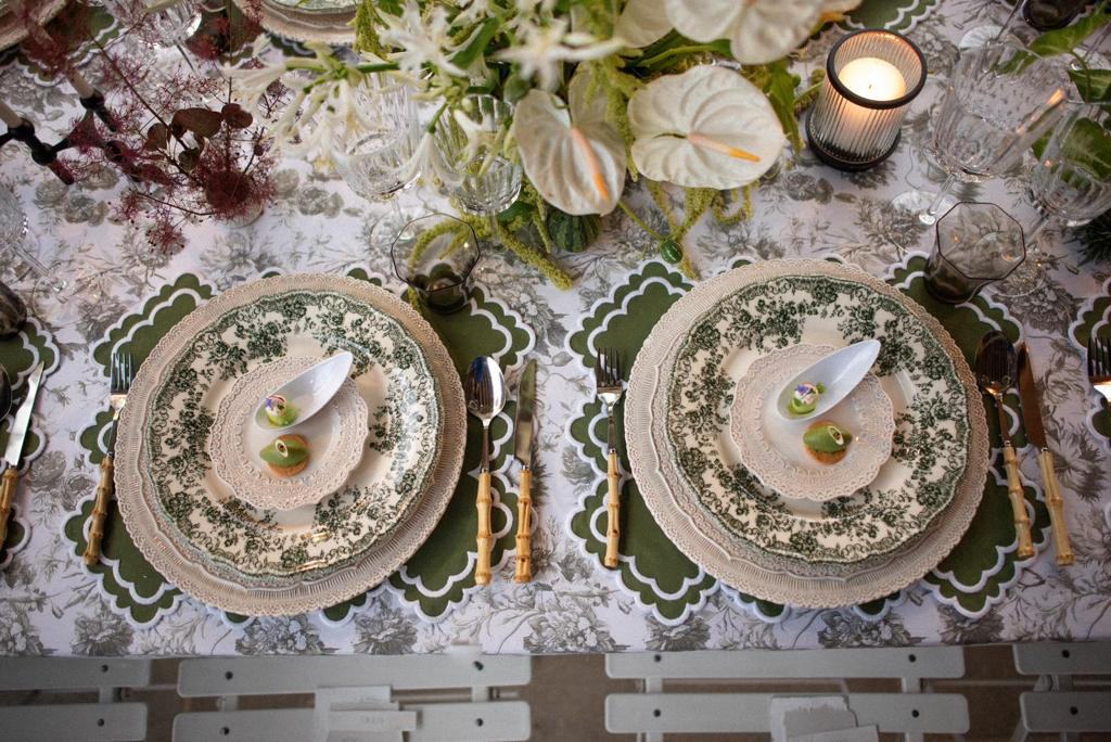 Green and white place settings on scallop-edged Appolonia placemats